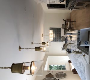 Pendant lights hang over a marble island in an updated kitchen.