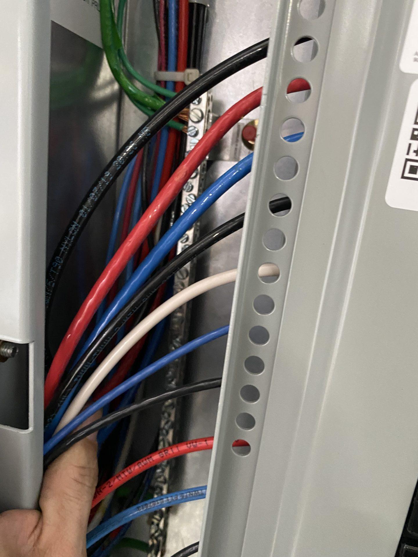 Image showing 3 phase panel with cover removed and colorful phase conductors in view.