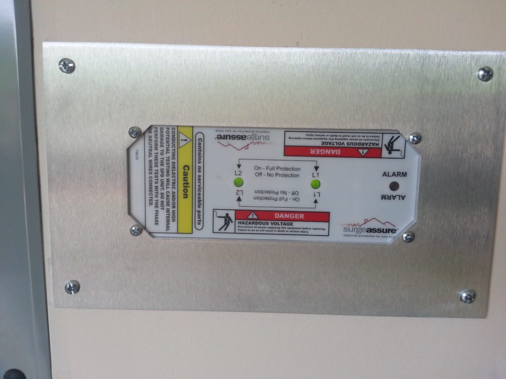 SurgeAssure Surge Protection Device installed in wall with aluminum finish plate