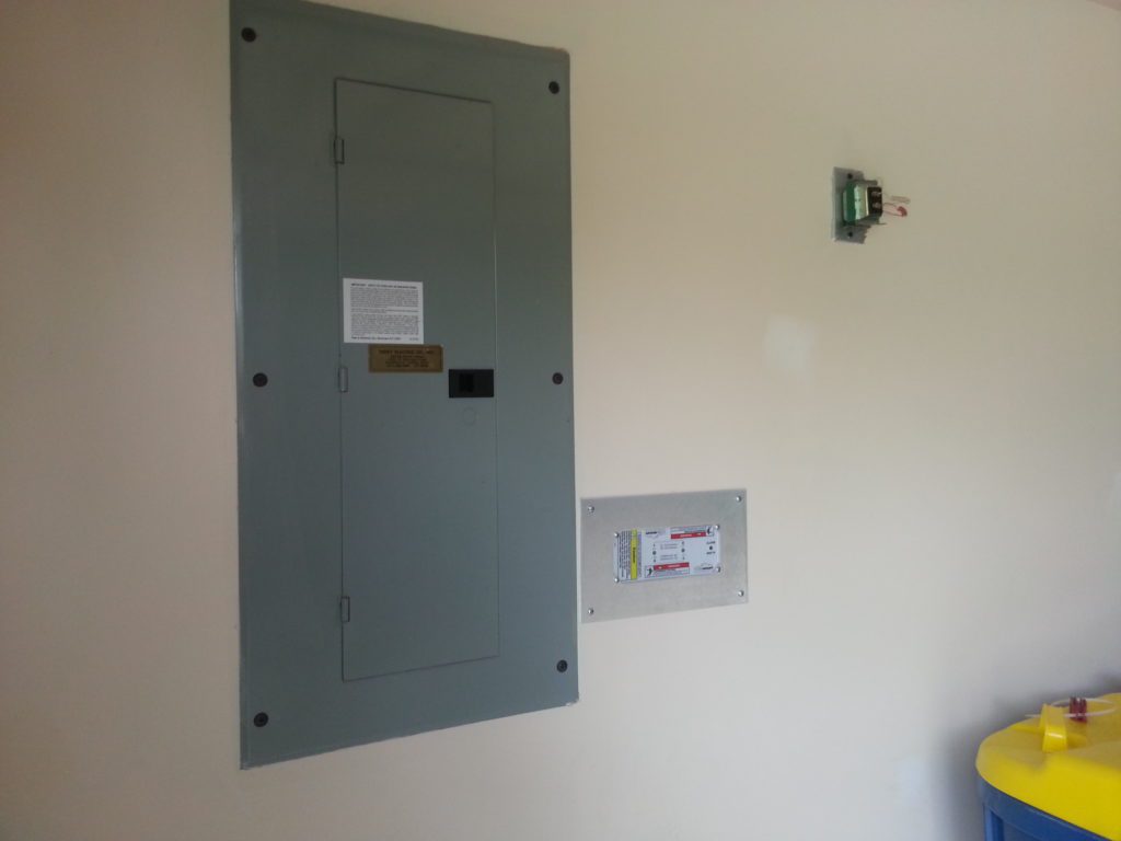 Overview of SurgeAssure SPD installed adjacent panel in wall with aluminum finish plate.