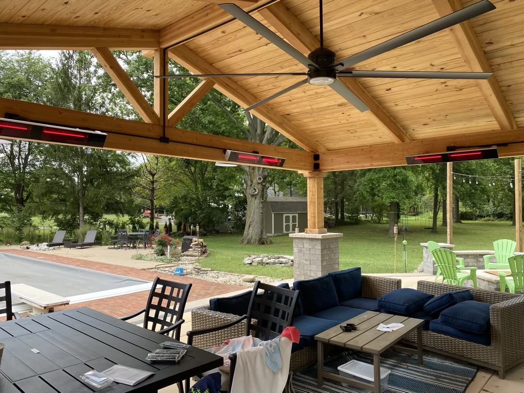 Outdoor pavilion in upscale backyard with infrared heaters and ceiling fan with light.